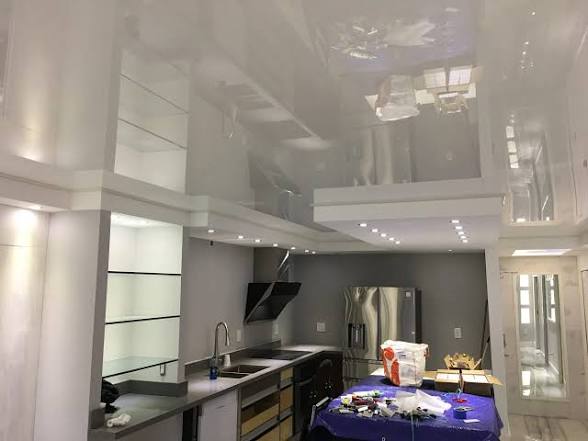 Completed glossy stretch ceiling installation in Coral Gables kitchen with integrated LED lighting